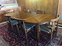 Full set of dining table with four chairs arranged around and two arm chairs.