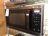 Front-left angle view showing microwave LED display and keypad controls.