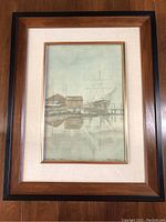 Full view of the framed artwork showing the entire piece with wooden frame, beige matting, and golden inner border.