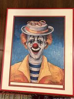Full view of framed clown print signed by artist Red Skelton, showing clown with yellow jacket and hat.