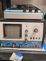 Front view of Electro-Lab Design Console Oscilloscope Model IOD-4540 showing CRT screen with grid, knobs and switches on front panel, blue and white casing.
