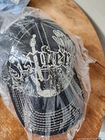 Black Fender ball cap in original packaging showing white Fender logo and graphic design