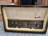 Front view of the antique Telefunken Orchester radio showing control knobs, tuning dial, speaker grille and buttons. Shows aging marks.