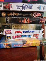 Photo showing stacked VHS movie cases including The Man from Left Field, Harry Potter and the Philosopher's Stone, The Mummy, The Lord of the Rings: Fellowship of the Ring, Baby Geniuses, Like Mike, and Stuart Little 2.