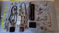 Full view of assortment of costume jewelry arranged on a grey surface.