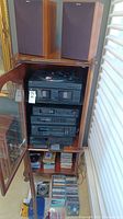 Pair of Jamo speakers on top of cabinet next to window