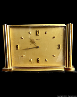 Front view of the antique Swiss Imhof 8-day table clock with gold face and black base.
