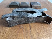 Photo of bronze sculptures on wooden surface showcasing three pieces in the set