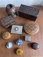 Top view showing all items including wooden candle holder and various vintage vessels in different materials and patterns.