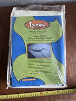 Packaged fitted bondage sheet labeled Lusty Linen Sleep Tight, showing front packaging with product details and image of sheet tied to bed corner.