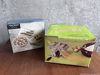 Boxes of Olympia pasta maker and Joshua Maxwell Studio olive plate set.