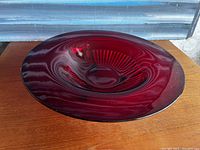Top-down view of deep ruby red glass bowl showing ribbed center and smooth wide rim.