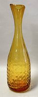 Full view of amber-colored 10.5 inch tall blown glass vase with textured dimpled pattern and flared rim