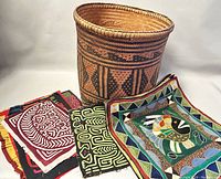 Handmade woven basket along with three fabric pieces showing designs and colors