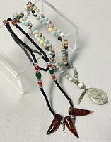 Full view of both beaded stone necklaces showing beads and pendants.
