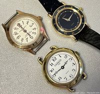 Overall view showing three watches together on fabric background