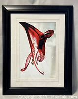 Full view of framed watercolor artwork with black frame and white mat showing red flower petal