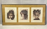 Full view of the framed triptych of the three signed prints, showing all portraits within the single large frame.