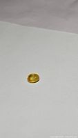 Top side view of the natural canary yellow oval cut sapphire showing color and faceting