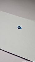 Photo of pear-shaped deep lagoon blue Swiss blue topaz gemstone on white surface showing size and color