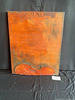 Frontal view of the artwork showing the textured background, the violin carving at bottom, and 'PLAY ME' text at the top.