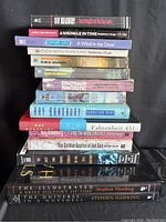 Stack of sixteen science fiction books by various authors including Ray Bradbury, Madeleine L'Engle, Stephen Hawking, and others.