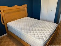 Full front view of assembled wooden bed frame with mattress
