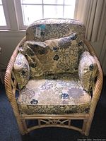 Front view of bamboo style chair showing floral cushions and bamboo frame detail.