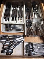 Top view of flatware set showing forks, knives, and spoons arranged in plastic trays