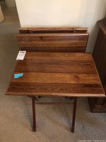 Front view of one wood folding tray unfolded, showing wood grain and foldable legs