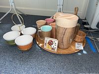 Wide view showing all items of the vintage barware set including pitcher, tray, snack bowls, carrier, wicker holder and coasters on floor.