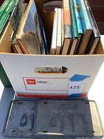 Box with hardback books on Saudi Arabia and two old Saudi license plates beneath.