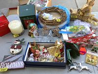 Overview of lot items showing wreath, ornaments, crystal candy dish, decorative stars, and boxed smaller ornaments