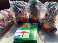 Three plush mice with drums and a Christmas tree stand in packaging