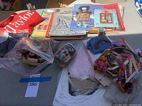 Overview of all items showing sewing patterns, fabric, embroidery floss skeins, and thread spools spread out on table