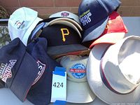 Overview of all hats in the lot showing different colors, logos, and styles piled together.