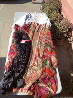 Full view of the Middle Eastern clothing draped over a table including robe, tunic, and pants.