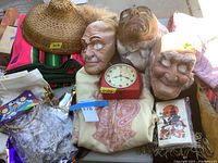 Rubber masks, vintage clock, Pendleton wool blanket, wool poncho, and black velvet shawl arranged together.