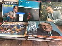Photo showing assorted vinyl album covers including Perez Prado, Stan Getz Quartet, Pete Fountain, Glen Gray, and Dave Brubeck Quartet.