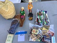 Top-level view of lot showing Thai figurines, stir sticks in bags, matchbook packs, and woven basket.