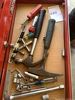 Drawer with assorted tools including claw hammers, screwdrivers, tire gauge, and sockets