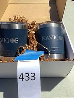 Two navy blue Yeti Navigoe travel mugs in a white box with packing paper, showing branding on the side