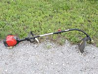 Full side view of Craftsman gas weed trimmer showing red engine housing, curved shaft, loop handle and cutting guard