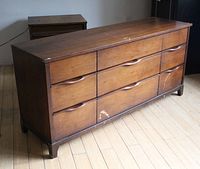 Front and side view of a wooden mid-century modern dresser showing significant wear and scratches on surface and drawers.