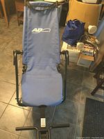 Photo of the blue AB Lounge abdominal workout chair set up in a room on tiled floor, showing full item and frame detail