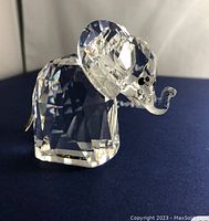 Close-up of the clear faceted Swarovski crystal elephant figurine showing detail of the eyes, trunk, and tail