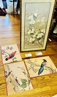 Three unframed prints laid out on floor showing different birds and floral scenes in Asian style