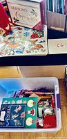 Box containing Christmas greeting cards, stickers, angel book and crochet candle