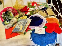 Lot of crochet yarn, handmade hats, covers, scarf, crochet supplies including needles and patterns, and beads.