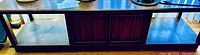 Photo of mid-century coffee table showing the wood top and central storage cabinet.
